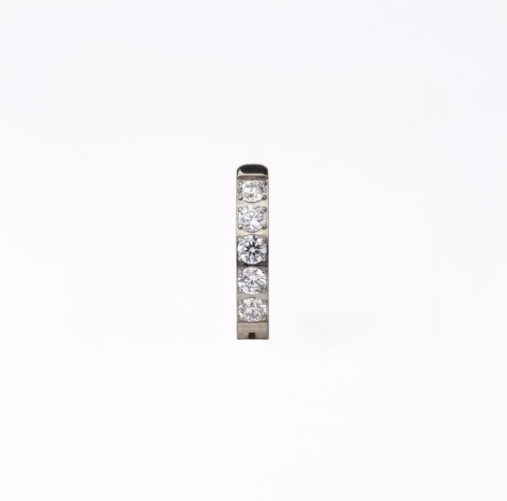 Piercing nombril en titane doré ou argenté avec zircons facettés lumineux et design fin à l’allure minimaliste.