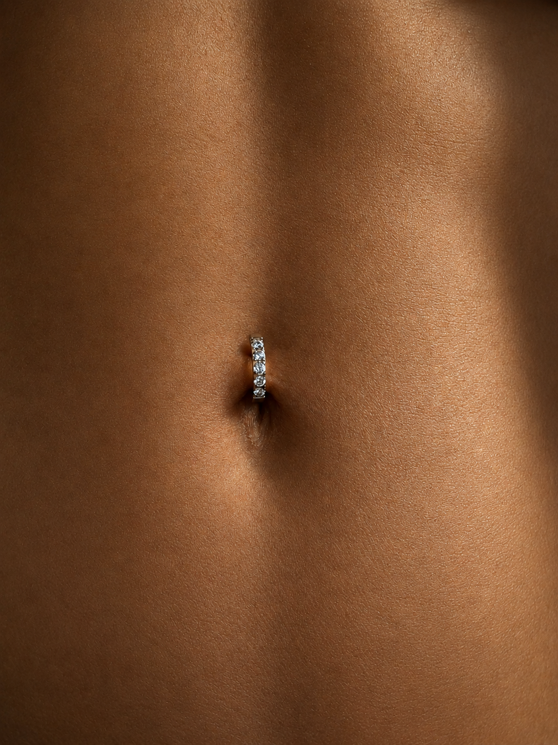 Piercing nombril en titane argenté avec zircons facettés lumineux et design fin à l’allure minimaliste.