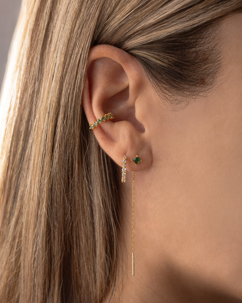 ELARA ear cuff with green zirconia stones by Isadora Boutique, worn on the ear.