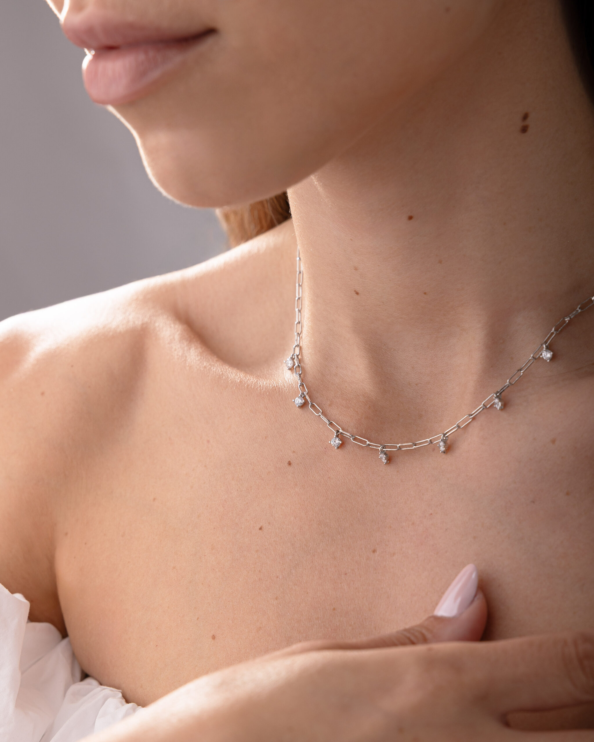 Collier NOXY en argent sterling 925, disponible en finition argentée ou dorée, orné de zircones blanches suspendues.