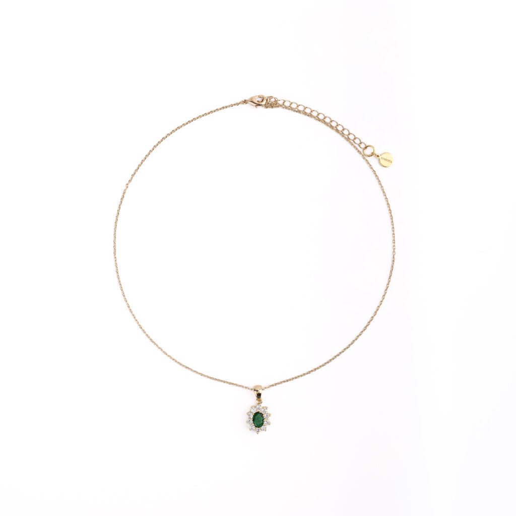 Collier PROMESSE doré avec pendentif orné d’une zircone verte entourée de zircones blanches.