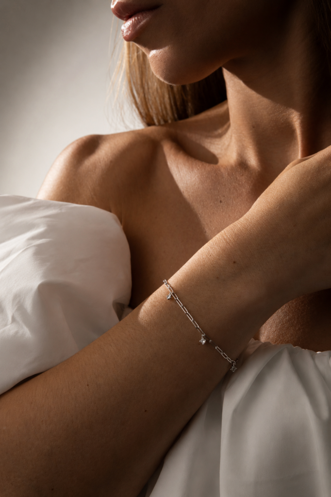 NOXY bracelet in 925 sterling silver, available in silver-tone or gold-tone finishes, adorned with white cubic zirconia delicately suspended along the chain.