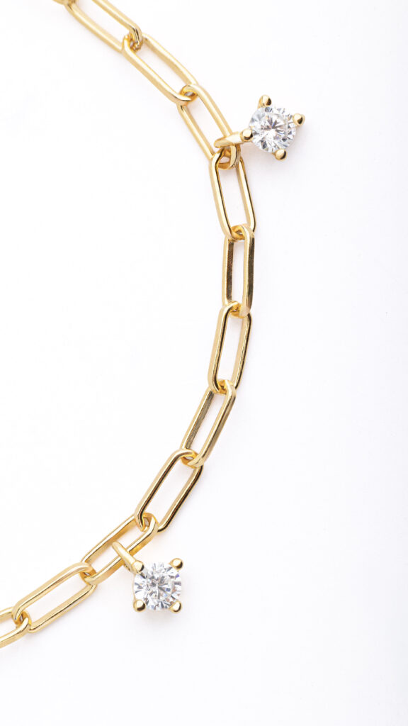 NOXY bracelet in 925 sterling silver, available in silver-tone or gold-tone finishes, adorned with white cubic zirconia delicately suspended along the chain.