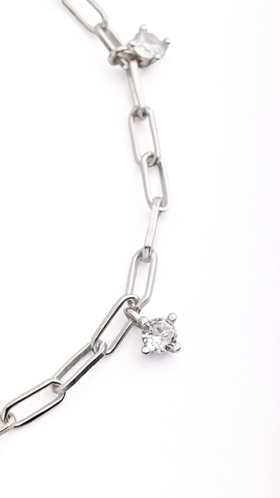 NOXY bracelet in 925 sterling silver, available in silver-tone or gold-tone finishes, adorned with white cubic zirconia delicately suspended along the chain.