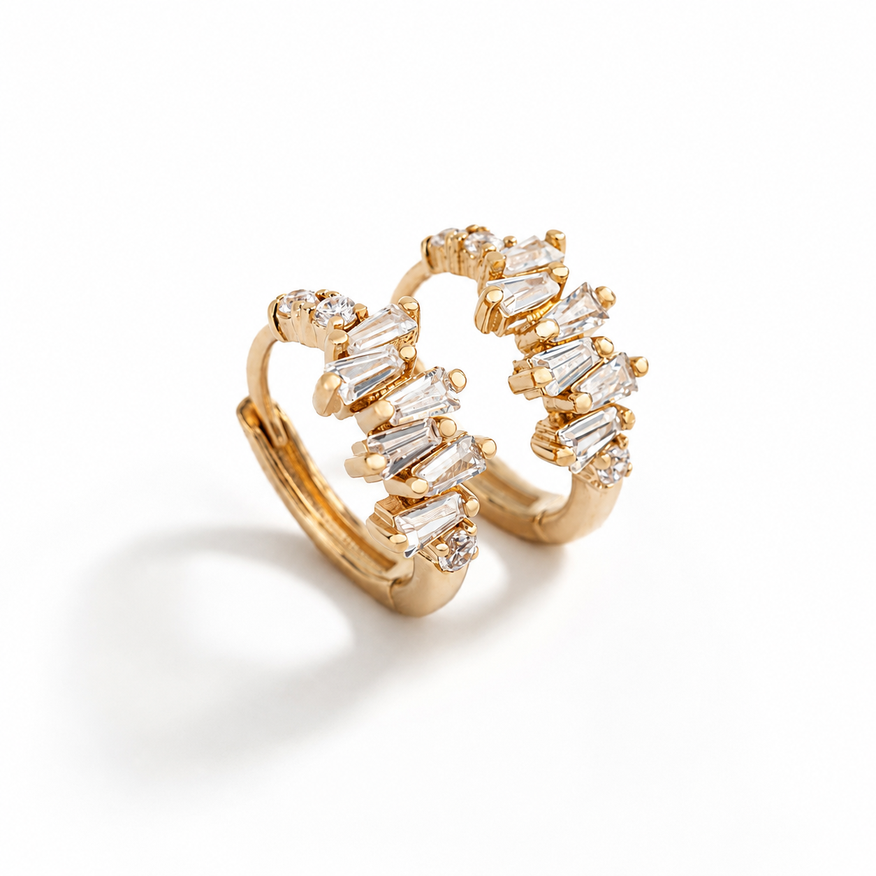 Boucles d’oreilles MIRA en laiton recouvert d’or 18 carats, ornées de zircones taille baguette.