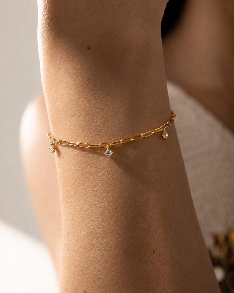 NOXY bracelet in 925 sterling silver, available in silver-tone or gold-tone finishes, adorned with white cubic zirconia delicately suspended along the chain.